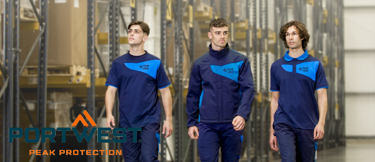 Tres jóvenes con ropa de trabajo uniforme en diferentes tonos de azul. Al fondo se pueden ver estantes de almacenamiento y en la zona inferior izquierda de la imagen se puede encontrar el logotipo del fabricante de ropa de trabajo Portwest.