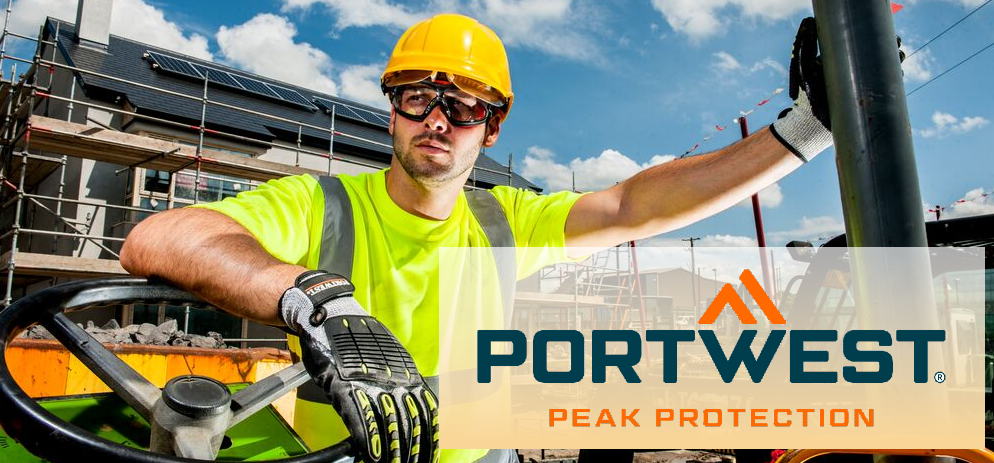 Trabajador de la construcción con gafas de seguridad, casco y guantes en una obra; en primer plano, el logotipo de Portwest con el eslogan "Peak Protection".