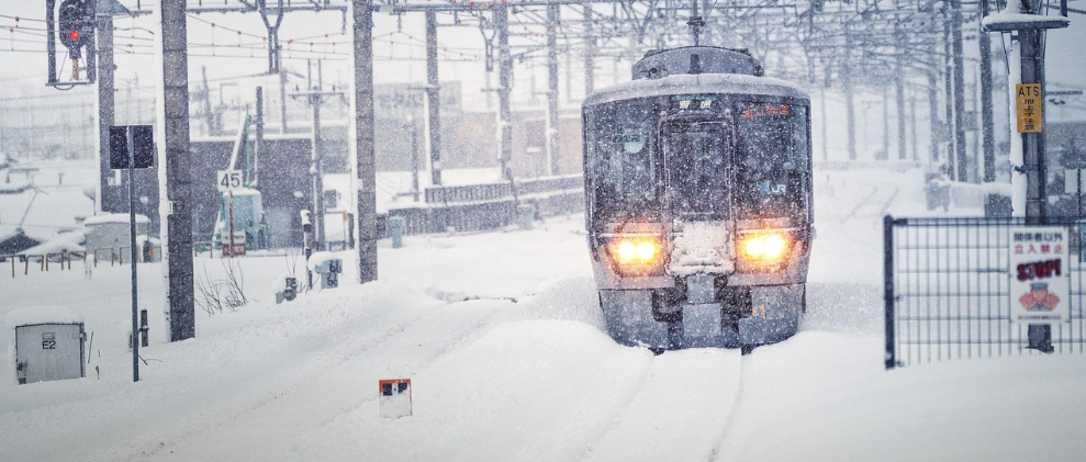 Vista frontal de un tren. Las v&iacute;as est&aacute;n cubiertas de nieve y la visibilidad es deficiente debido a la nieve que cae.