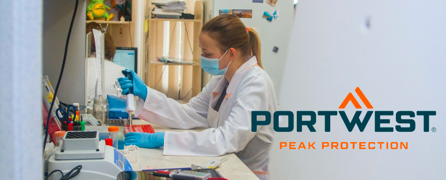 Científico en el laboratorio con bata blanca, guantes azules y una máscara mientras trabaja con una pipeta. Logotipo de Portwest con el lema «Peak Protection» en primer plano.