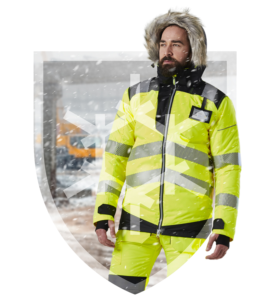 Trabajador barbudo sobre un fondo nevado en forma de escudo con una capucha forrada de piel en la cabeza y ropa de trabajo amarilla de alta visibilidad. Enlace a la colección de invierno.