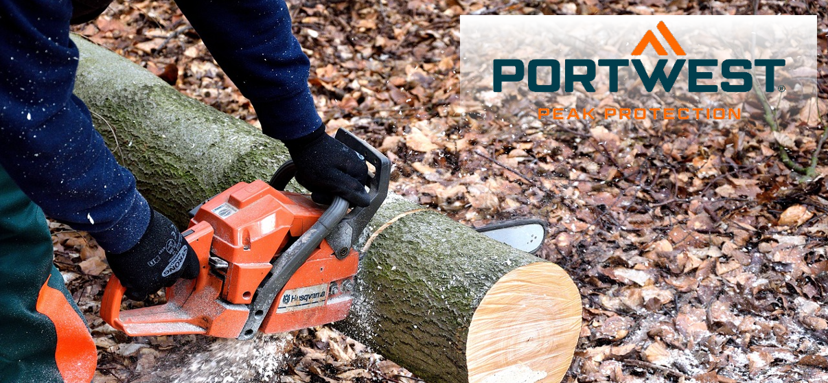 Se ve a una persona usando una motosierra para cortar el tronco de un árbol tirado en el suelo. Al fondo se ven hojas marrones de otoño y astillas de madera voladoras. En la esquina superior derecha de la imagen está el logo de Portwest en azul y naranja sobre un fondo blanco transparente.