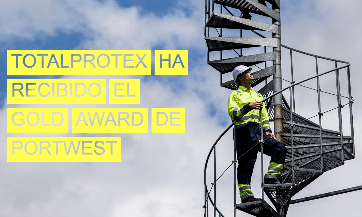 Un trabajador vestido con ropa amarilla de advertencia sube una escalera de caracol y mira al cielo. Al fondo se puede ver un cielo azul con nubes blancas. La imagen lleva el título 'Totalprotex ha recibido el Gold Award de Portwest'.